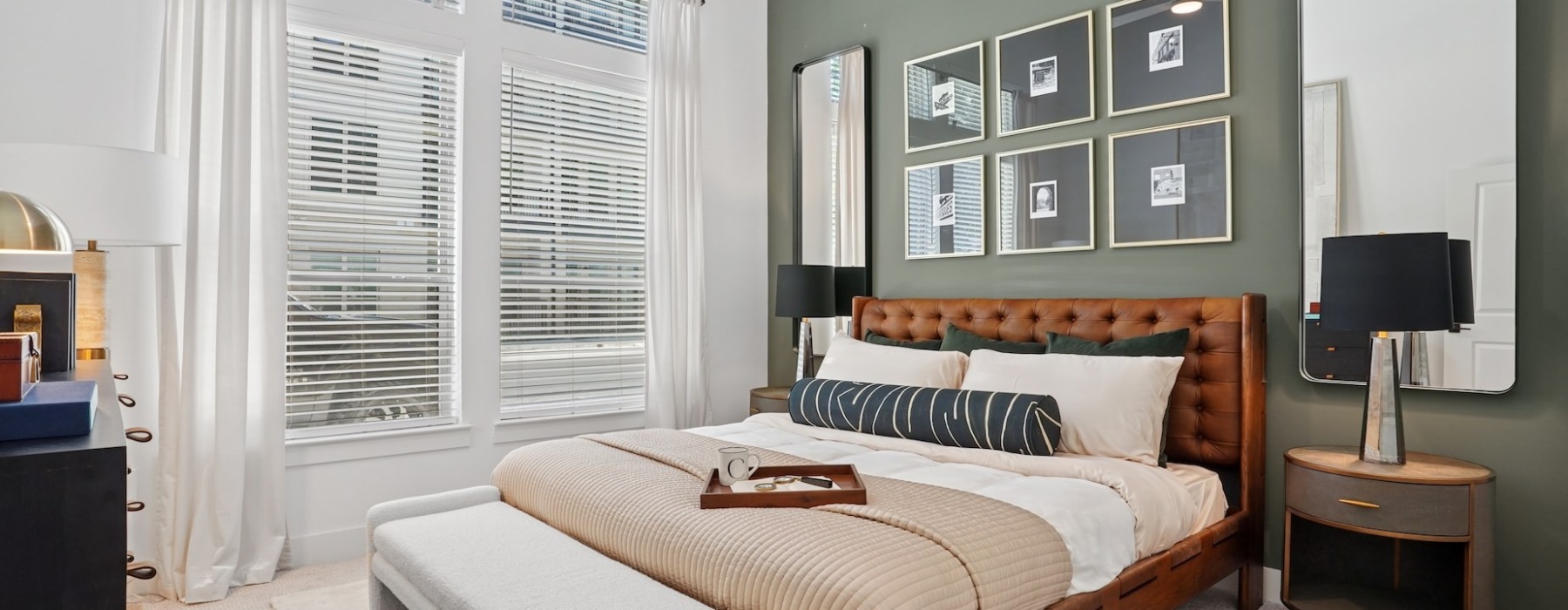 Furnished bedroom with a large window inside an apartment home at Copper Bishop Arts